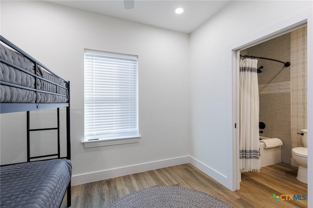 bedroom with wood-type flooring and ensuite bath