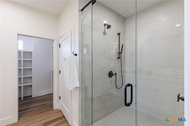 bathroom featuring wood-type flooring and an enclosed shower