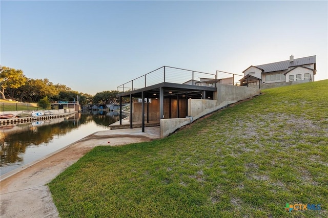 dock area featuring a lawn and a water view