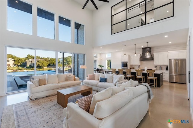 living room with ceiling fan and a high ceiling