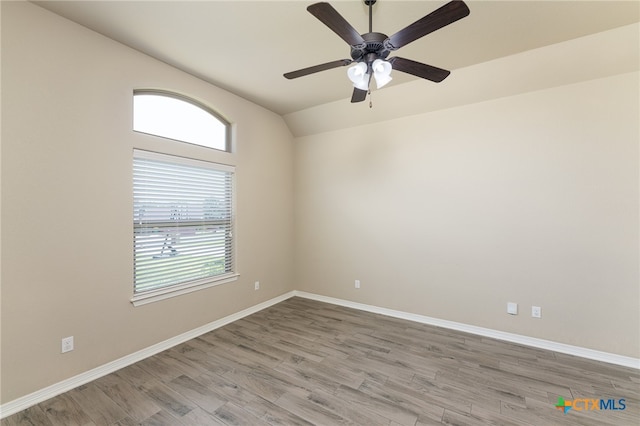 empty room with hardwood / wood-style floors, ceiling fan, and vaulted ceiling