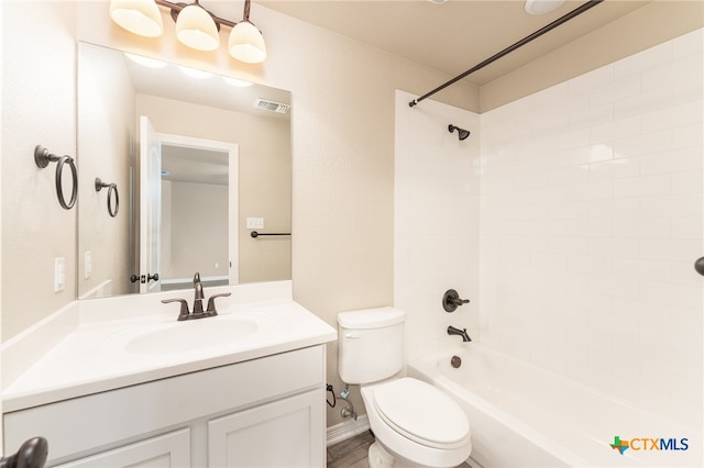 full bathroom featuring vanity, tiled shower / bath, and toilet