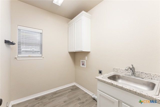 clothes washing area with light hardwood / wood-style floors, electric dryer hookup, cabinets, sink, and washer hookup