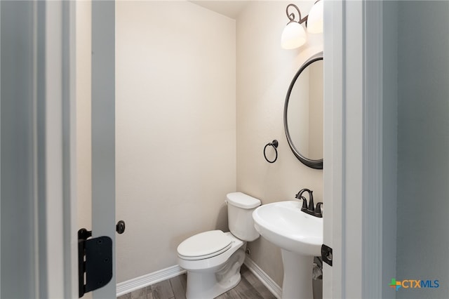 bathroom with hardwood / wood-style floors, sink, and toilet