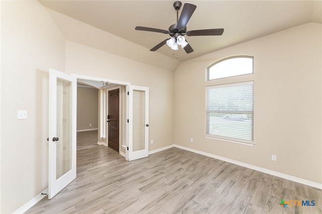 unfurnished room featuring french doors, light hardwood / wood-style flooring, ceiling fan, and vaulted ceiling