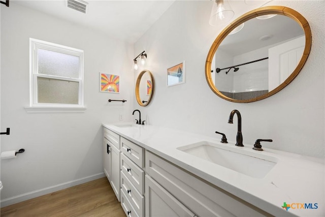 921 Indian Trl, Harker Heights, TX 76548 - full bathroom with double vanity, wood finished floors, baseboards, and toilet