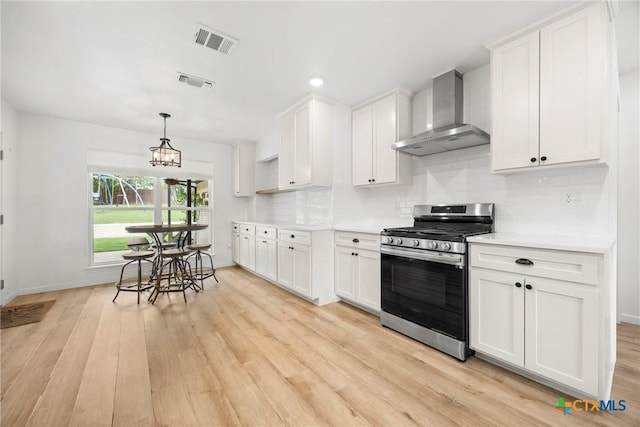 921 Indian Trl, Harker Heights, TX 76548 - kitchen featuring stainless steel range with gas stovetop, wall chimney range hood, light wood-style flooring, white cabinetry, and recessed lighting