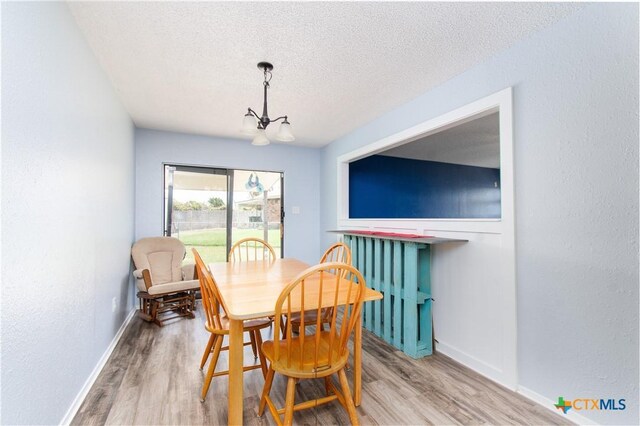 3605 Pleasing Cir, Killeen, TX 76542 - dining area with wood finished floors, a textured ceiling, a chandelier, and a textured wall