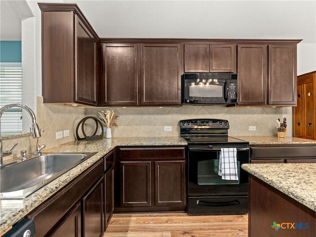 2416 Kolton St, New Braunfels, TX 78130 - kitchen with black appliances, light wood-style floors, dark brown cabinets, and light stone countertops