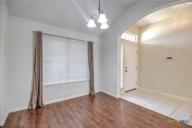 1900 Rutherford Dr, Leander, TX 78641 - foyer entrance with arched walkways, a chandelier, wood finished floors, and vaulted ceiling