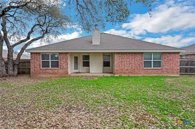 back of property with a yard and a patio area