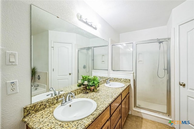 bathroom with tile patterned flooring, vanity, and a shower with shower door