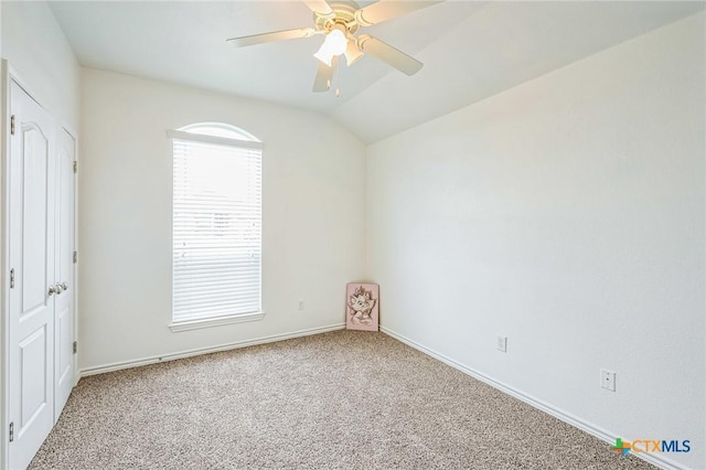 carpeted empty room featuring ceiling fan and lofted ceiling