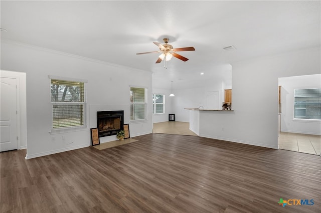 unfurnished living room featuring ceiling fan, ornamental molding, and dark hardwood / wood-style flooring