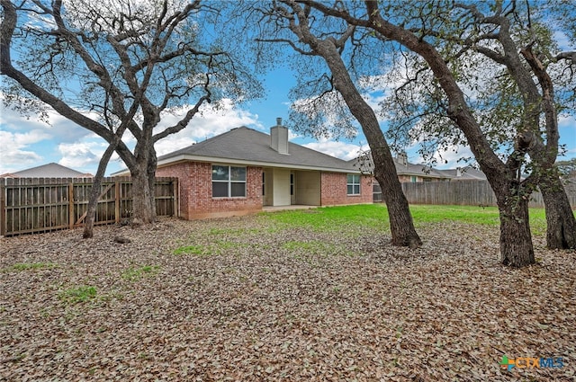 rear view of house featuring a yard