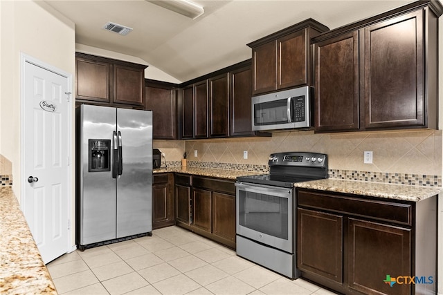 kitchen featuring lofted ceiling, decorative backsplash, light tile patterned floors, dark brown cabinets, and stainless steel appliances