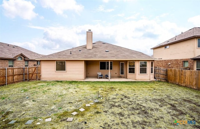 back of house featuring a patio area and a yard