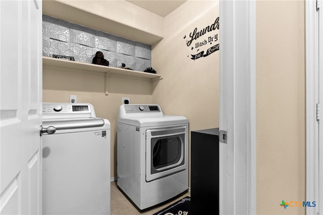 laundry room featuring washer and clothes dryer and light tile patterned flooring