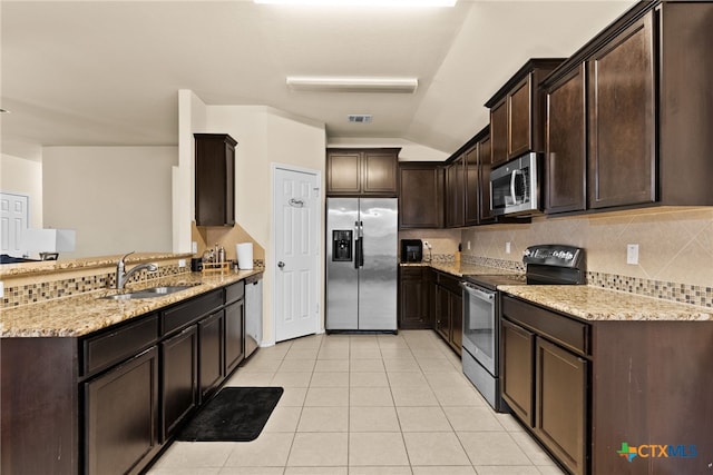 kitchen featuring light tile patterned floors, tasteful backsplash, light stone counters, dark brown cabinetry, and stainless steel appliances