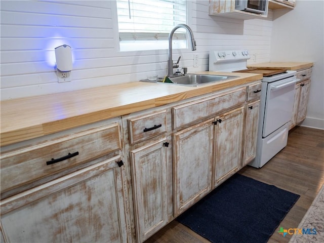 kitchen featuring dark wood finished floors, butcher block counters, white range with electric cooktop, and a sink