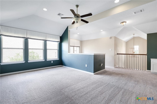 empty room with ceiling fan with notable chandelier, light colored carpet, and lofted ceiling