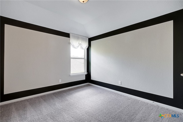 empty room featuring carpet and lofted ceiling