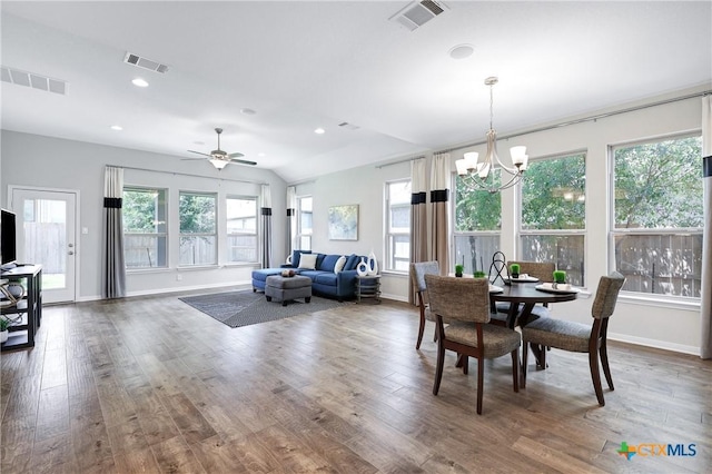 dining area featuring a healthy amount of sunlight, ceiling fan with notable chandelier, and hardwood / wood-style floors