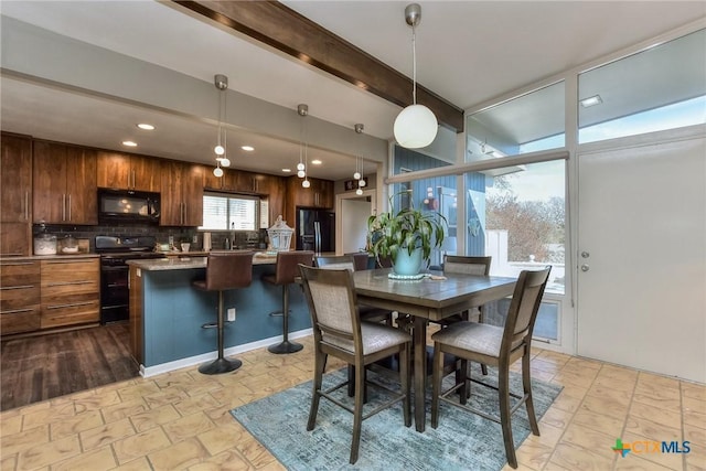 dining area with sink and beam ceiling