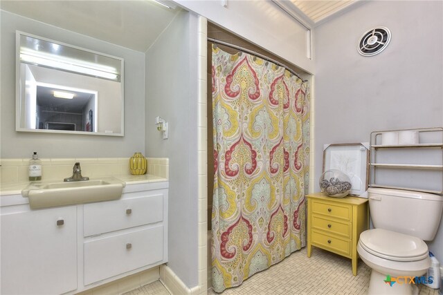 bathroom featuring toilet, vanity, and walk in shower