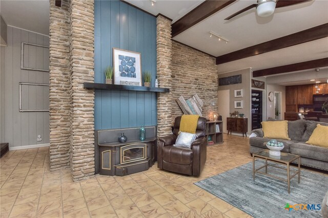 living room with beam ceiling, a wood stove, ceiling fan, and wood walls