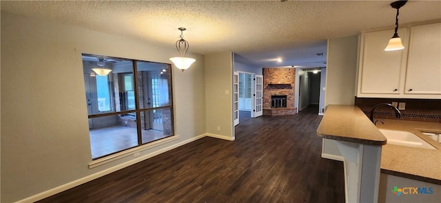 217 Taylors Dr, Temple, TX 76502 - dining room with a fireplace, dark wood finished floors, baseboards, and a textured ceiling