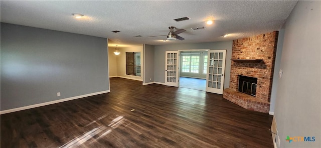 217 Taylors Dr, Temple, TX 76502 - unfurnished living room with ceiling fan, a textured ceiling, dark wood-style flooring, baseboards, and a fireplace