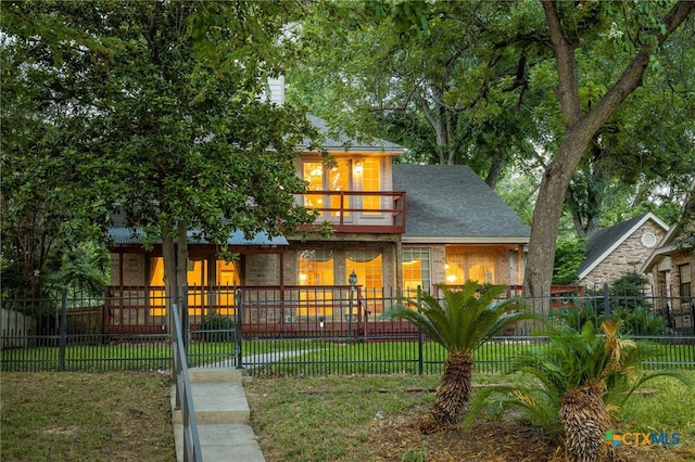 view of front of house with a front yard and a balcony