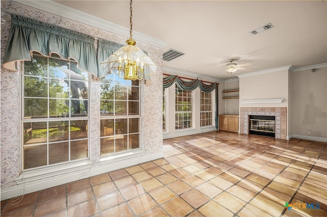 interior space featuring ceiling fan with notable chandelier, a fireplace, tile patterned floors, and crown molding