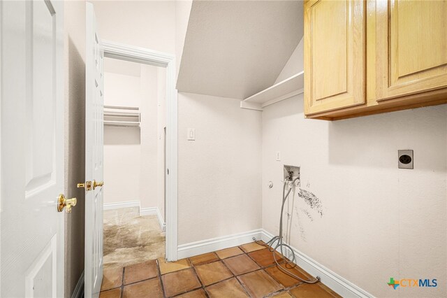 clothes washing area featuring hookup for an electric dryer, hookup for a washing machine, cabinets, and light tile patterned floors