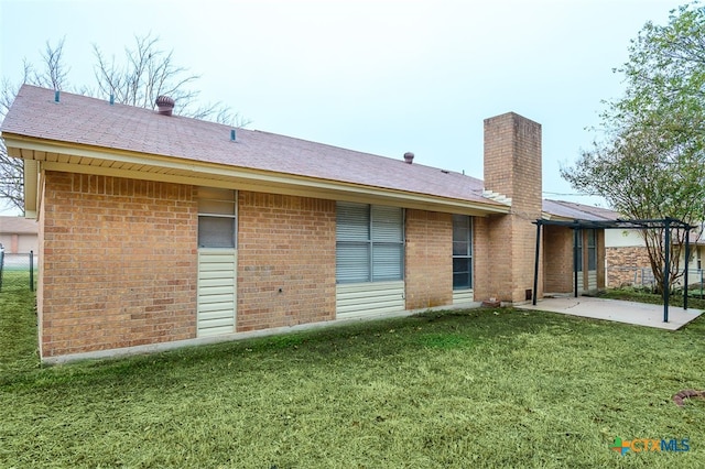 back of house featuring a patio and a yard