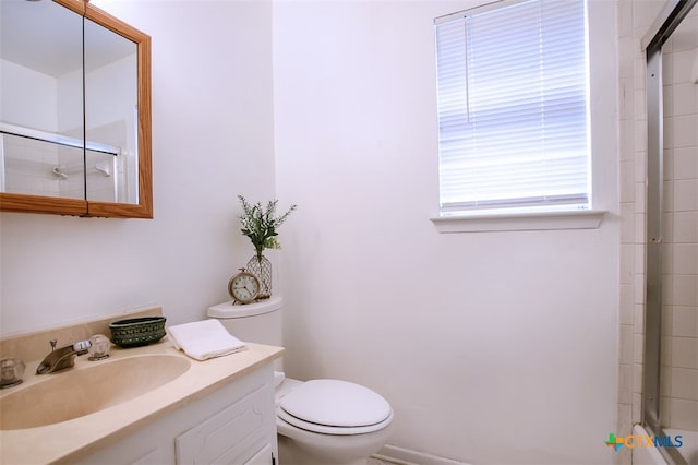 bathroom with a shower with shower door, vanity, and toilet