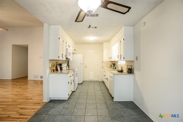 kitchen with ceiling fan, a textured ceiling, white appliances, white cabinets, and light wood-type flooring