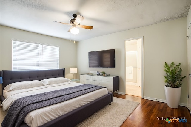 bedroom with dark hardwood / wood-style flooring, ceiling fan, and ensuite bath