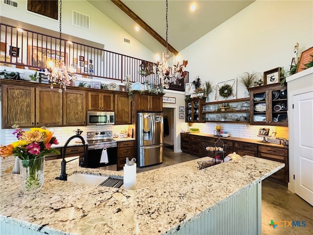 kitchen featuring high vaulted ceiling, a notable chandelier, visible vents, stainless steel appliances, and a sink