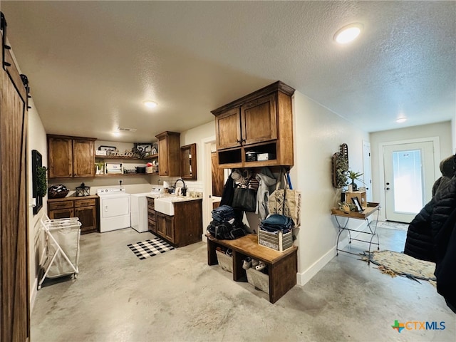 kitchen featuring concrete floors, separate washer and dryer, a textured ceiling, light countertops, and open shelves