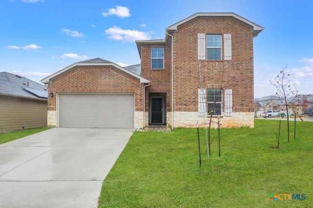 view of front property featuring a front lawn and a garage