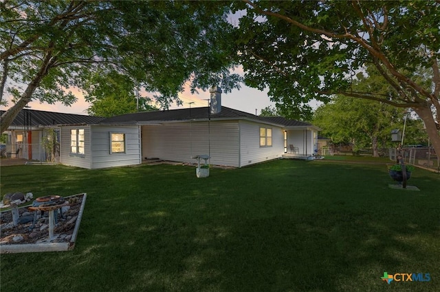 134 Daisy Ln, Whitney, TX 76692 - back of property at dusk featuring a chimney
