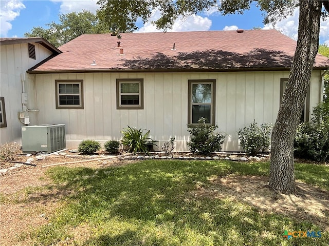 exterior space with central AC and a yard