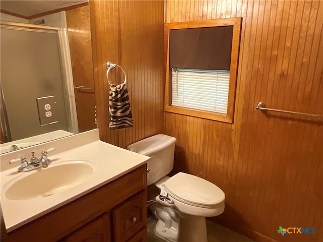 bathroom with wood walls, a shower with shower door, vanity, and toilet