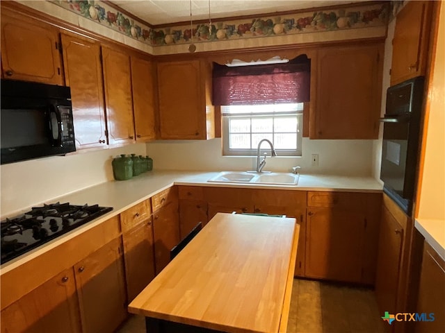 kitchen featuring black appliances, butcher block countertops, and sink