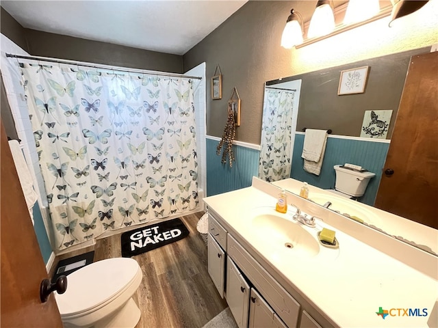 bathroom with wood-type flooring, toilet, vanity, and a shower with shower curtain