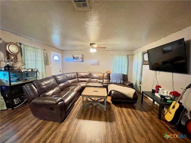 living room with a textured ceiling, hardwood / wood-style floors, and ceiling fan