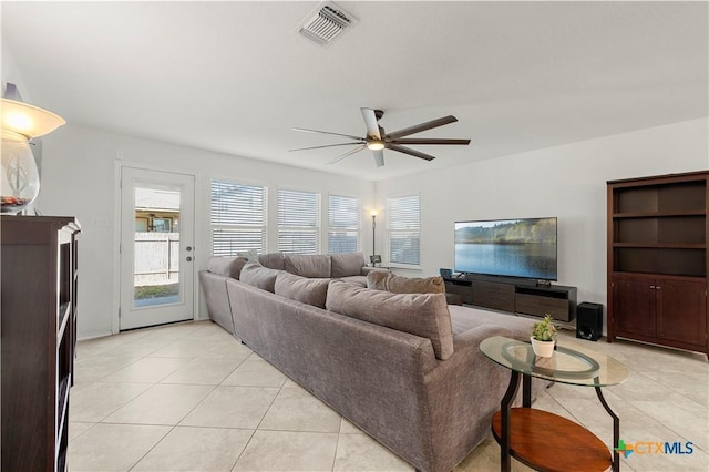 living room featuring light tile patterned floors, visible vents, and ceiling fan