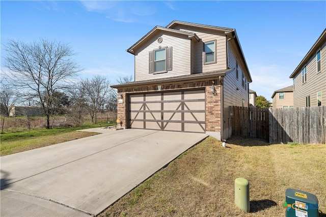 traditional-style home with driveway, fence, a front yard, an attached garage, and brick siding